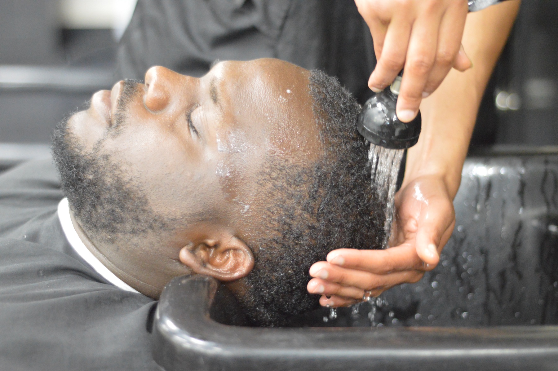 Client mid-shampoo at the portable bowl in a salon suite, Laurel MD